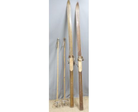 A pair of vintage hardwood skis and poles, the skis with metal edges, length 212cm