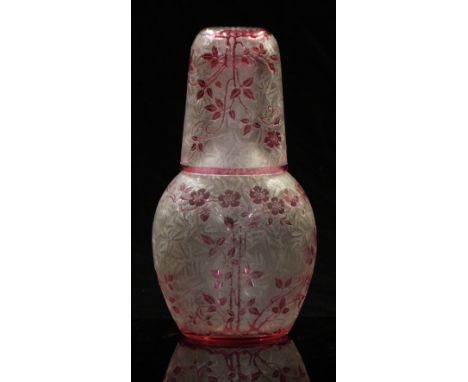 Baccarat carved cameo glass decanter and cup with cranberry decoration of flowers over an etched opaque ground, 20.5cm tall.&