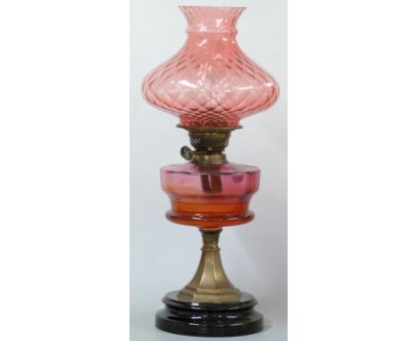 A late 19th / 20thC oil lamp with cranberry glass bowl and shade, 54cm tall