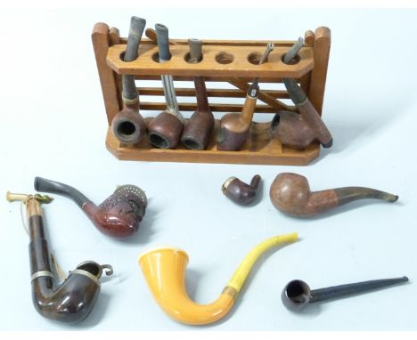 A collection of vintage pipes including Meerschaum, briar etc, and a pipe rack