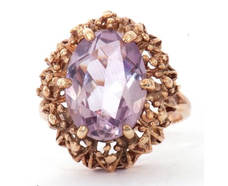 Vintage 9ct gold purple stone dress ring, the oval cut faceted purple stone in a pierced bead decorated mount, raised by spli