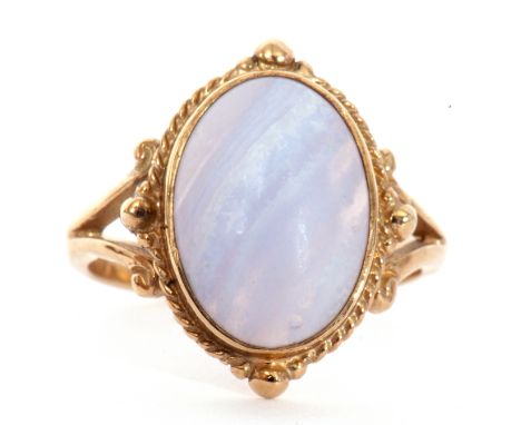 9ct gold and quartz ring, a cabochon centre pale quartz, bezel set and framed in a bead and split shoulder mount, size N