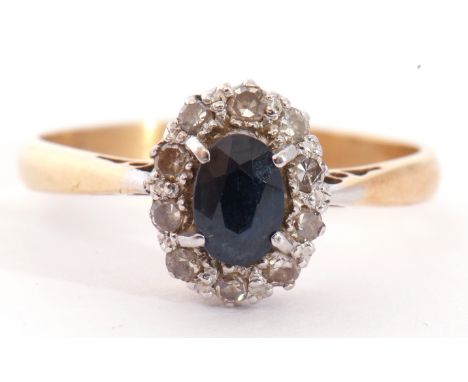 Sapphire and diamond cluster ring, the oval shaped faceted sapphire raised above a small diamond surround, stamped 18ct and P