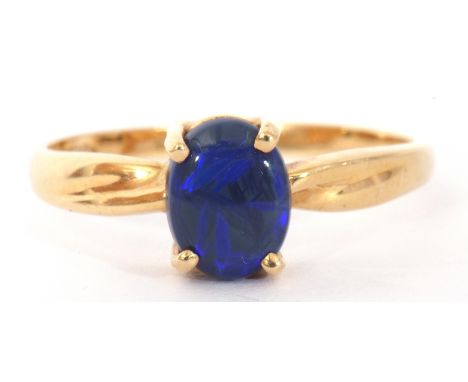 Modern black opal doublet ring, the oval shaped opal is four claw set and raised in a plain polished mount, stamped 750, size