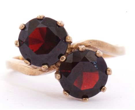 9ct gold and garnet cross over ring featuring two round faceted cut garnets, multi-claw set in coronet setting to a plain pol