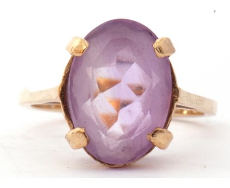 Modern 9ct gold pale purple stone ring, the oval faceted purple stone four claw set raised in a basket mount, size N