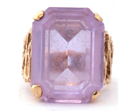 Modern large light purple stone dress ring, featuring a stepped cut purple stone, four claw set and raised in a basket mount 