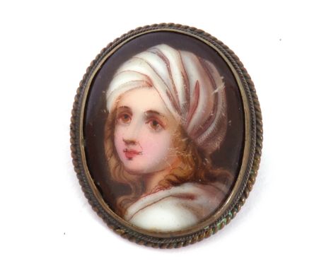 Vintage porcelain painted oval brooch depicting a head and shoulders portrait of a young lady, framed in a metal mount, 33 x 