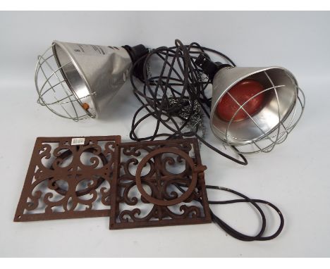 A pair of vintage infra red heat lamps and a pair of cast iron, wall mountable flowerpot holders.
