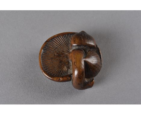 An early 19th Century boxwood carved netsuke, modelled as a mushroom with two water chestnuts, 3.8 cm x 4 cm  