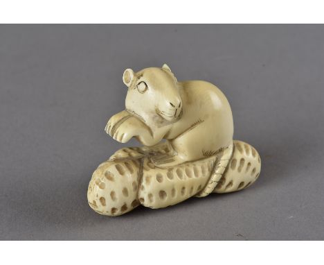 A Meiji period signed Japanese ivory netsuke, modelled as a rat surmounting peanuts, indistinctly signed to underside, 3.5 cm