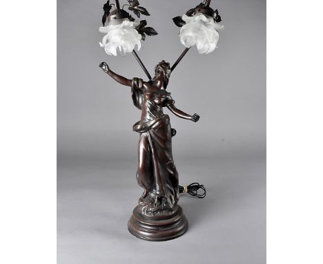 A continental figural table lamp, modelled as an art nouveau maiden supporting two large branches with frosted glass shades, 
