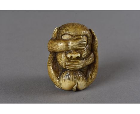 A carved Japanese signed ivory netsuke, modelled as a seated monkey, with its hands over its eyes and mouth and legs up cover