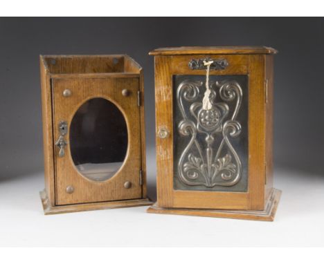 An Arts and Crafts oak and copper pipe cabinet, of narrow rectangular shape, with embossed copper stylised floral door half h