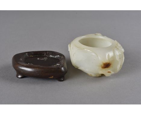 A 19th Century Chinese carved Jade water pot, of organic shape carved with two bats and leaves on a hardwood stand, pot 6 cm 