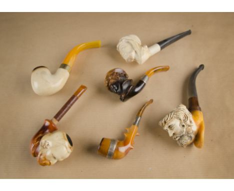 Three meerschaum pipe bowls with white metal mounts, two with carved lobed design, with wooden and horn stems one with antler