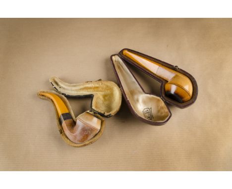 A cased meerschaum and amber pipe, brasenose shape together with a similar curved shaped example with amber mouthpiece, cased