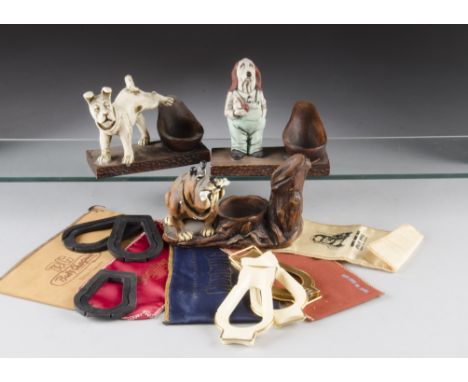A quantity of novelty pipe stands, including metal, glass, resin together with a quantity of silk pipe bags and other items (