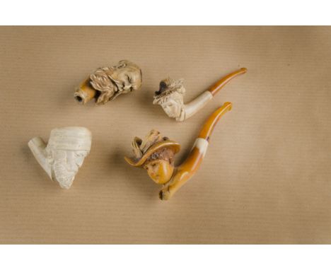 Two carved meerschaum cheroot holders, the bowls carved with young female heads, one with amber stem the other with simulated