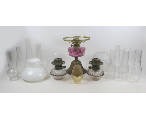 A Victorian paraffin lamp, with cranberry glass reservoir, base 23 by 33cm high, etched clear glass shade and chimney, togeth
