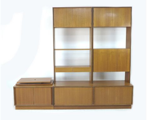 A G-Plan teak wall display shelving system, circa 1970, comprising two high level cupboard units, a fall front drinks cabinet