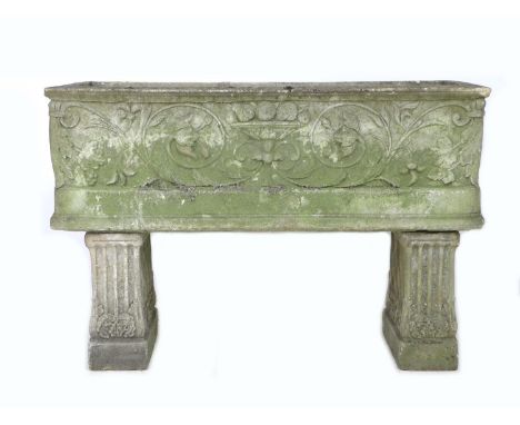 An early 20th century carved stone garden planter, of open coffin form with two drainage holes, decoratively carved with a fr