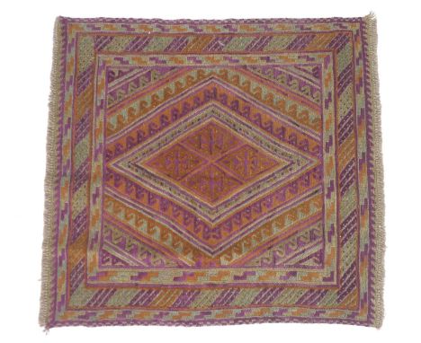 A Gazak rug, with orange, purple and light green diamond shaped decoration, latch hook edges, 117 by 113cm. 