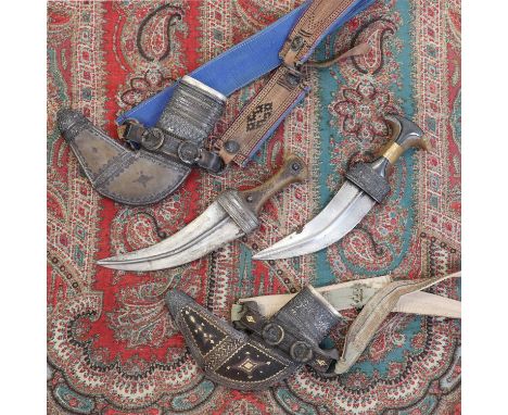 A steel jambiya,late 19th century, Omani, with horn hilt and in a white metal mounted scabbard, with embroidered belt,dagger 