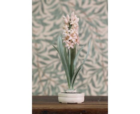 A carved and stained ivory okimono,Meiji period (1868-1912), Japanese, in the form of a hyacinth in bloom, bearing a two-char