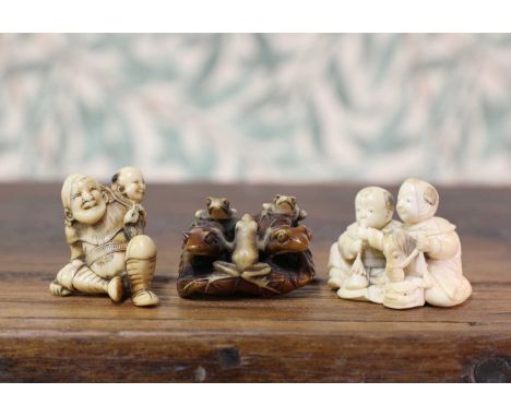 An ivory netsuke,Meiji period (1868-1912), Japanese, carved with two frogs and three smaller ones on top of a lotus leaf, sig