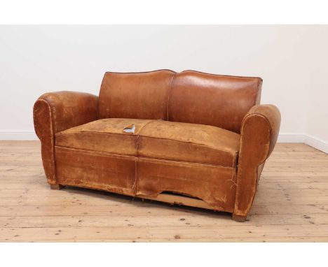 A leather sofa,c.1930s, French, with a shaped back, the seat cushion enclosing a pull-out bed,173cm wide88cm deep88cm highPro