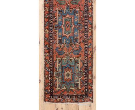 A Persian wool runner of narrow proportions,c.1890, Heriz, the field woven with repeating geometric medallions, within a flor
