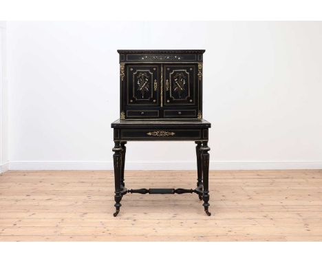 An ebonised bonheur-du-jour,late 19th century, French, the foliate-decorated frieze above pair of panel doors and drawers, wi