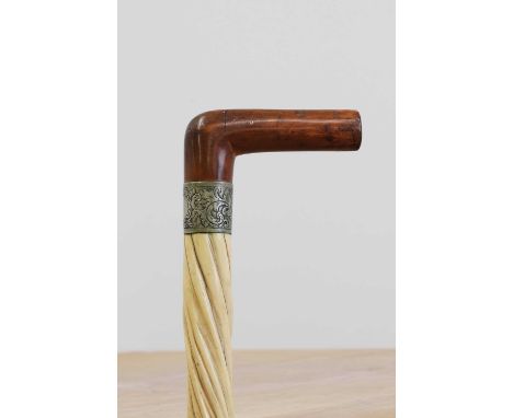 A narwhal tusk walking stick,late 19th century, the fruitwood handle above an engraved nickel collar with a vacant cartouche,