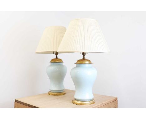 A pair of Chinese-style powder-blue glass table lamps,of recent manufacture, each of baluster form with giltwood mounts,25cm 
