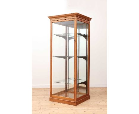 A golden oak glazed display cabinet, early 20th century and later, the stepped cornice above a door enclosing three shelves a