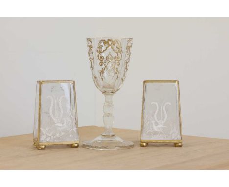 A Bohemian gilt glass cup, late 19th century, with latticino applied bands, raised on an opaque twist faceted stem,27cm high,
