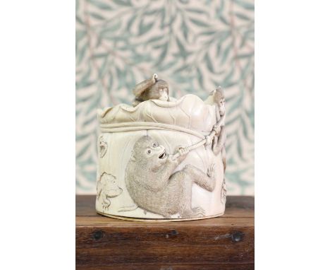 An ivory box and cover,Meiji period (1868-1912), Japanese, of cylindrical form in the shape of a lotus leaf, carved with monk