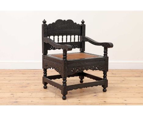 A finely carved ebony armchair,18th century, Indian, Coromandel Coast, the shaped back with a turned arcaded panel surmounted
