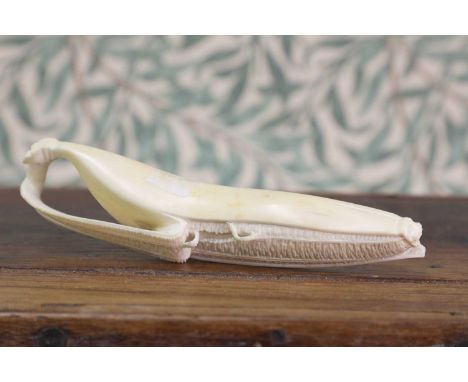 A carved ivory okimono,Meiji period (1868-1912), Japanese, carved in the form of a banana with partially-peeled skin, 17cm lo