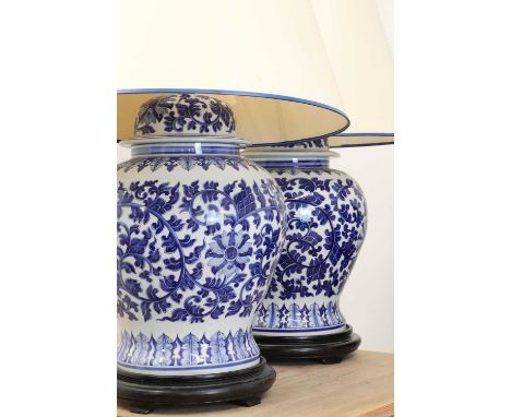 A pair of Chinese blue and white vase table lamps,20th century, with painted floral designs on turned, ebonised stands, each 