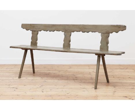 A painted bench,early 19th century, Scandinavian, with a silhouette carved back rail and supports, to a plank seat and stick 