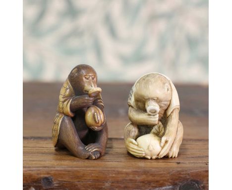 An ivory okimono,Meiji period (1868-1912), Japanese, carved with a seated monkey studying a peach with a magnifying glass, si
