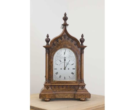 A Victorian Gothic walnut table clock,late 19th century, by John Moore &amp; Sons, Clerkenwell, the arching silvered dial wit