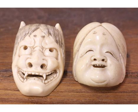 An ivory netsuke,Meiji period (1868-1912), Japanese, in the shape of a Noh mask, signed 'Shinzan', 5cm long,together with ano