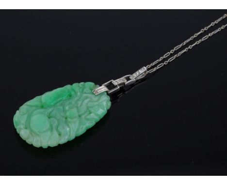 An Art Deco carved and pierced jade pendant with unmarked white gold diamond set mount, length 57mm on unmarked white gold ch