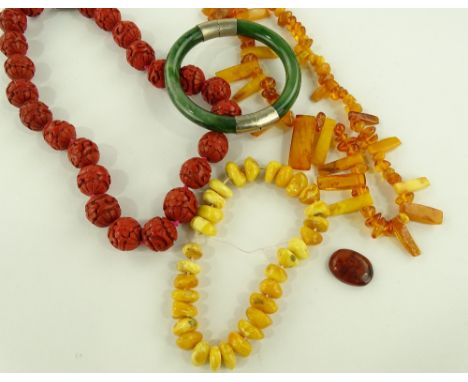 A string of cinnabar beads, 2 strings of amber beads and a jade bracelet.