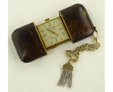 A gold plated Shields travelling clock in leather case, open outer case width 80mm, working order.