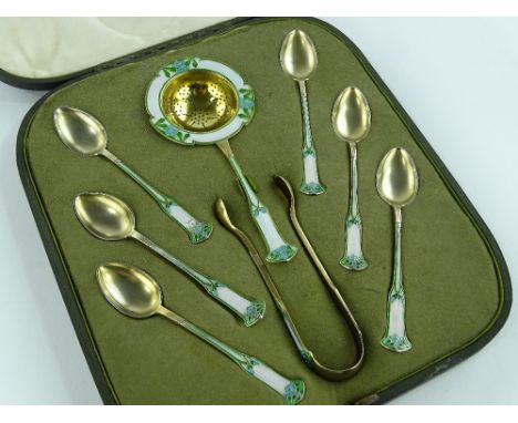 A Liberty & Co., Art Nouveau silver and coloured enamel tea strainer with matching teaspoons and tongs, all stamped Denmark, 