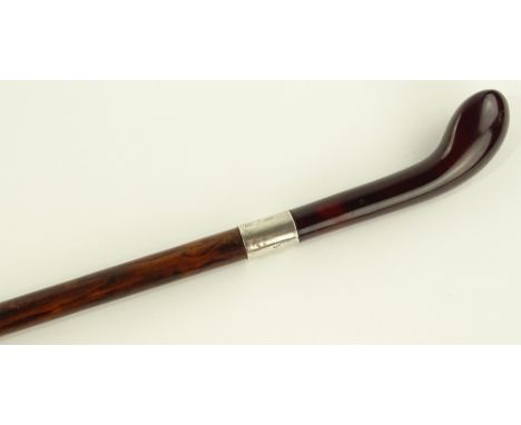 A simulated amber handled walking stick with silver collar.